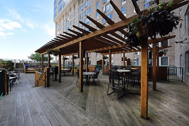wooden terrace featuring outdoor dining space and a pergola