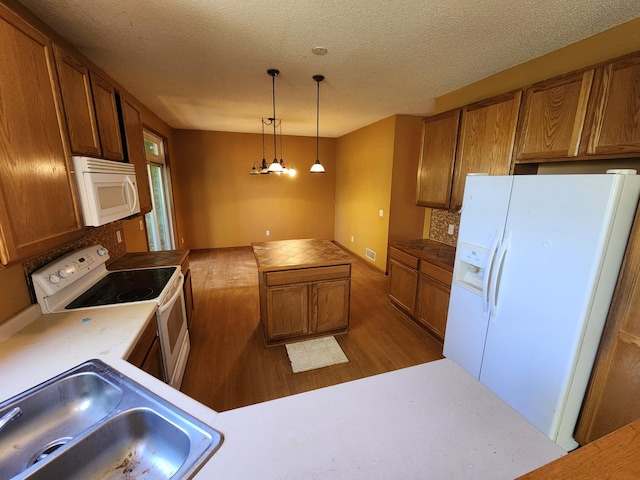3458 Savannah Ave, White Bear Lake, MN 55110 - kitchen featuring white appliances, a sink, brown cabinets, wood finished floors, and pendant lighting