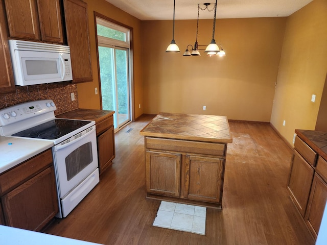 3458 Savannah Ave, White Bear Lake, MN 55110 - kitchen with white appliances, tile counters, wood finished floors, and backsplash