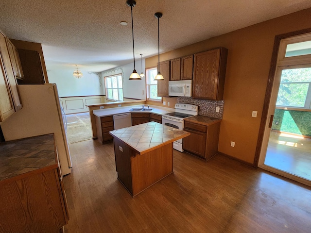 3458 Savannah Ave, White Bear Lake, MN 55110 - kitchen with white appliances, tile countertops, a peninsula, dark wood finished floors, and a sink