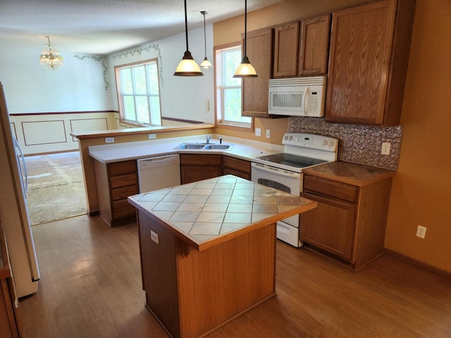 3458 Savannah Ave, White Bear Lake, MN 55110 - kitchen featuring white appliances, tile countertops, brown cabinets, wood finished floors, and wainscoting