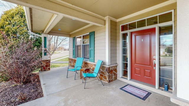 view of exterior entry featuring a porch and stone siding