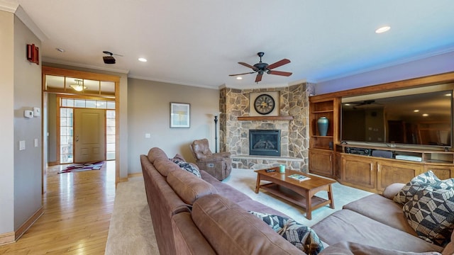 living room with crown molding, ceiling fan, light wood-style flooring, baseboards, and recessed lighting