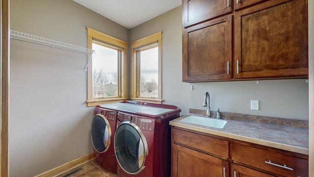 laundry room featuring cabinet space, washer and clothes dryer, baseboards, and tile patterned flooring