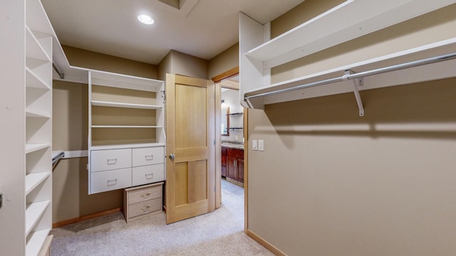 walk in closet featuring light carpet