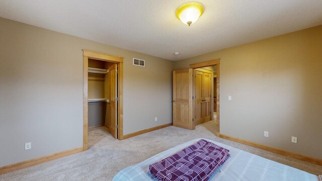 unfurnished bedroom featuring light carpet, baseboards, a spacious closet, and a closet