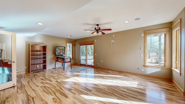 unfurnished living room with light wood-style flooring, healthy amount of natural light, a ceiling fan, baseboards, and recessed lighting