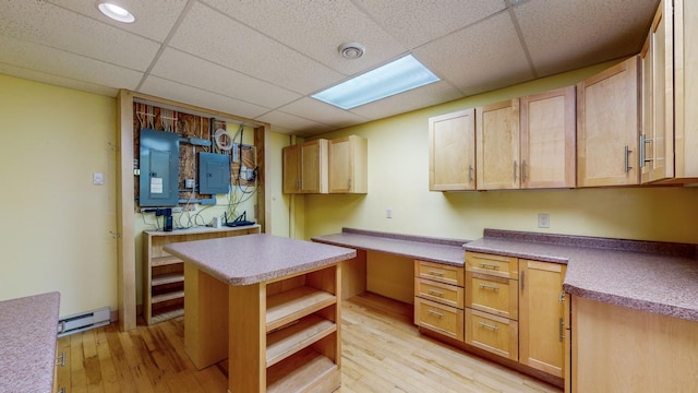kitchen featuring electric panel, light wood-style flooring, a baseboard heating unit, a paneled ceiling, and open shelves