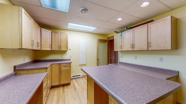 kitchen with light wood-style floors, a paneled ceiling, a baseboard radiator, recessed lighting, and a peninsula