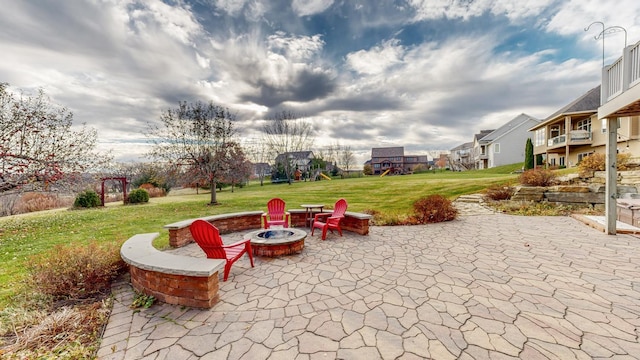 view of patio featuring a fire pit, a playground, and a residential view