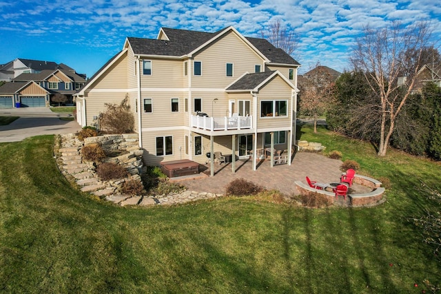rear view of house featuring a hot tub, a patio, a yard, and a deck