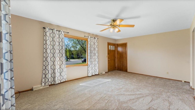 spare room featuring ceiling fan, carpet floors, and baseboards