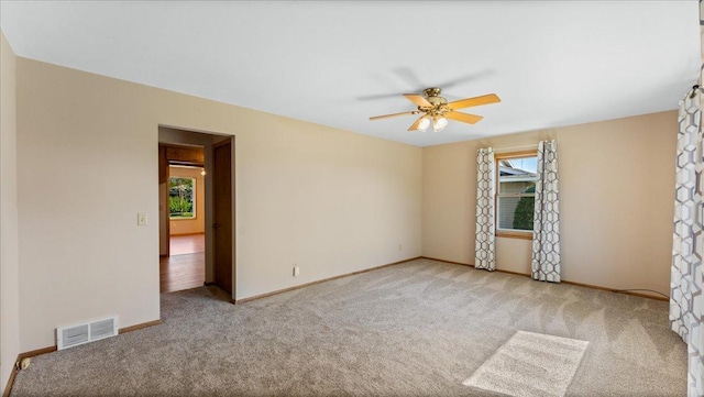 empty room with carpet floors, ceiling fan, and baseboards
