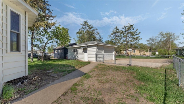 view of yard featuring a detached garage, an outbuilding, and a gate