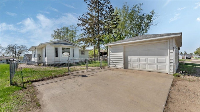 view of front of property featuring a detached garage, fence, a gate, and an outbuilding