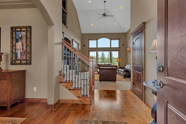 2255 Chelmsford Ln, Saint Cloud, MN 56301 - entryway featuring wood finished floors, a ceiling fan, stairway, high vaulted ceiling, and baseboards
