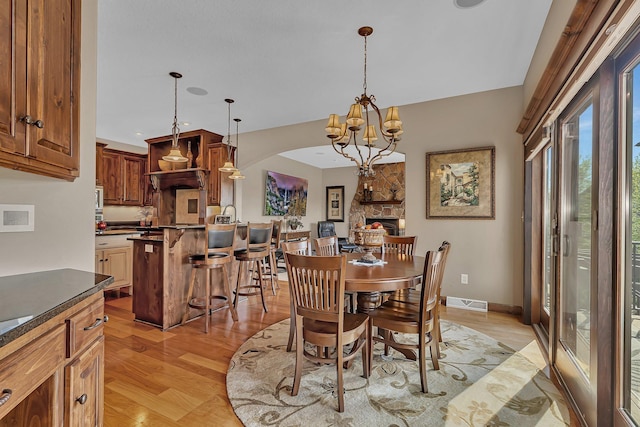 2255 Chelmsford Ln, Saint Cloud, MN 56301 - dining room with light wood-type flooring, a chandelier, arched walkways, recessed lighting, and baseboards