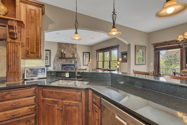 2255 Chelmsford Ln, Saint Cloud, MN 56301 - kitchen featuring a sink, arched walkways, pendant lighting, and brown cabinetry