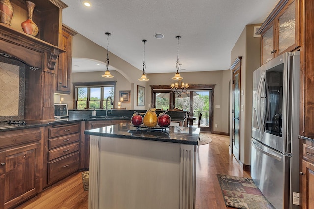 2255 Chelmsford Ln, Saint Cloud, MN 56301 - kitchen with smart refrigerator, a sink, light wood-style floors, a center island, and arched walkways