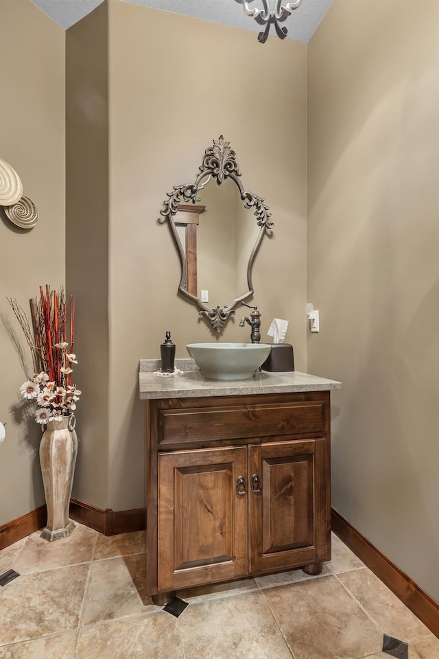 2255 Chelmsford Ln, Saint Cloud, MN 56301 - bathroom with baseboards, vanity, a chandelier, and stone finish floors