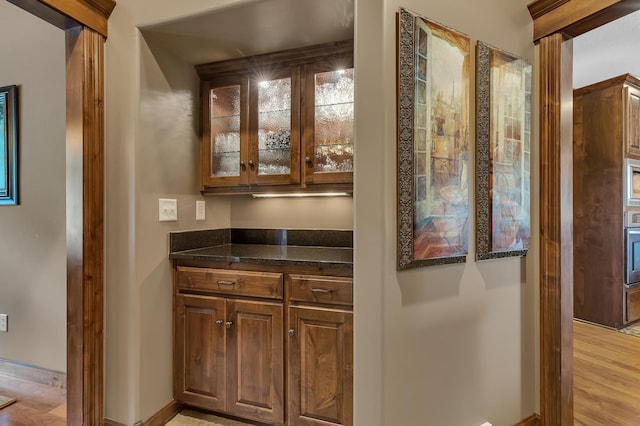 2255 Chelmsford Ln, Saint Cloud, MN 56301 - bar area with oven, baseboards, decorative columns, and light wood finished floors