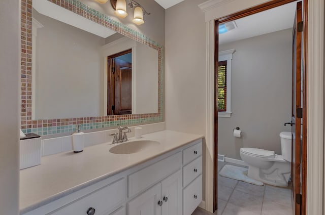 2255 Chelmsford Ln, Saint Cloud, MN 56301 - bathroom featuring vanity, toilet, tile patterned flooring, backsplash, and baseboards