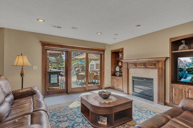 2255 Chelmsford Ln, Saint Cloud, MN 56301 - living area featuring built in shelves, a textured ceiling, a tiled fireplace, light carpet, and recessed lighting