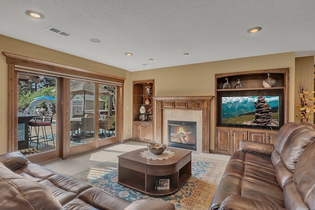 2255 Chelmsford Ln, Saint Cloud, MN 56301 - living room with a textured ceiling, built in shelves, a tile fireplace, recessed lighting, and light colored carpet