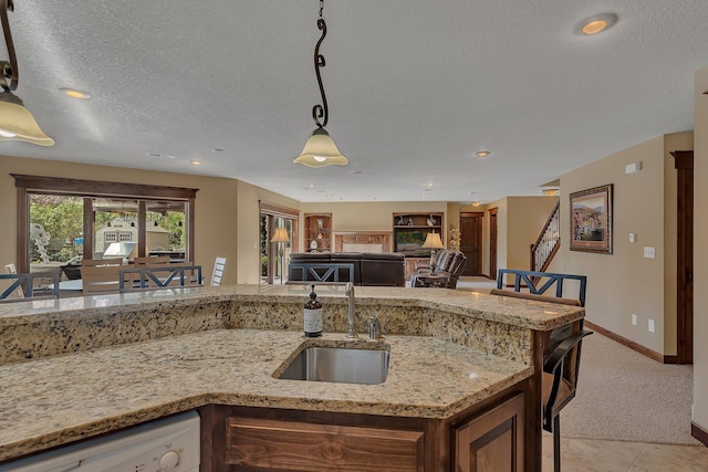 2255 Chelmsford Ln, Saint Cloud, MN 56301 - kitchen featuring a sink, dishwasher, pendant lighting, a textured ceiling, and light colored carpet