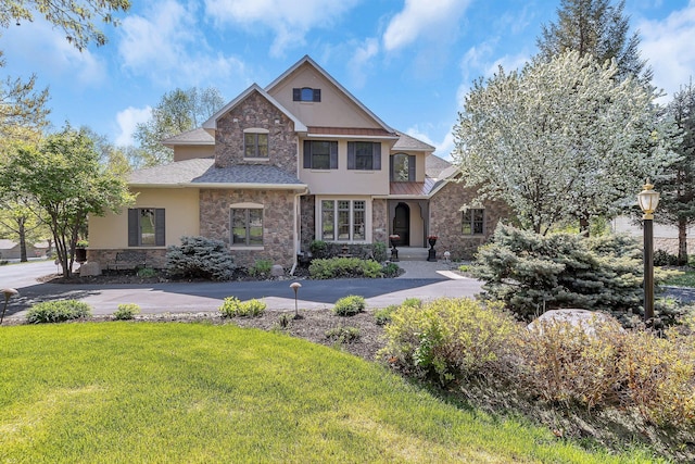 2255 Chelmsford Ln, Saint Cloud, MN 56301 - view of front of property featuring stone siding, stucco siding, a front lawn, and roof with shingles