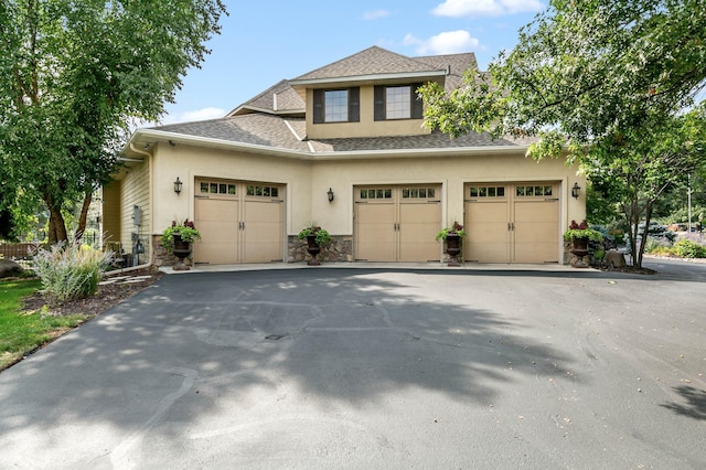 2255 Chelmsford Ln, Saint Cloud, MN 56301 - view of front of house featuring stone siding, stucco siding, a shingled roof, driveway, and an attached garage