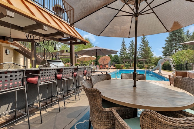 2255 Chelmsford Ln, Saint Cloud, MN 56301 - view of patio / terrace with stairs, an outdoor pool, outdoor dining space, and exterior bar