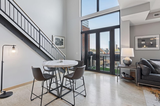 dining area with a high ceiling and stairway