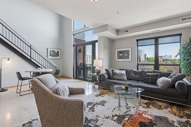 living area with baseboards and stairs