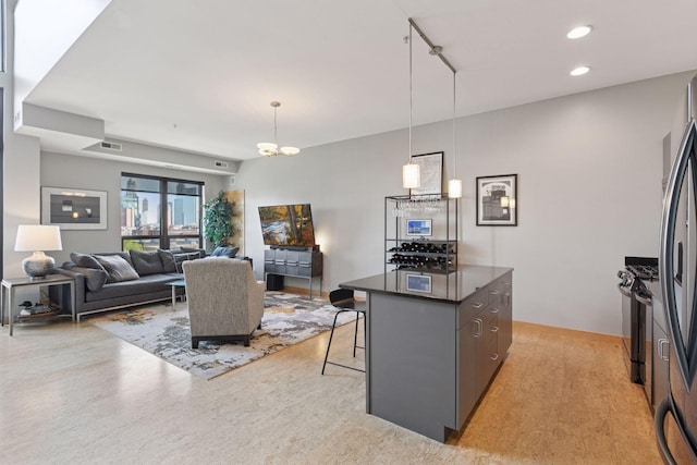 kitchen with dark countertops, a breakfast bar, a kitchen island, freestanding refrigerator, and recessed lighting