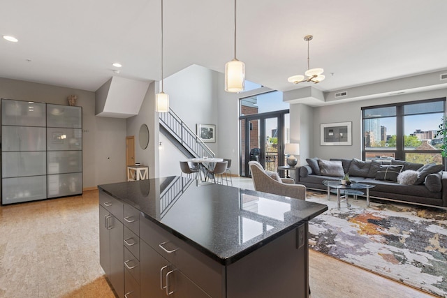 kitchen with pendant lighting, a kitchen island, a chandelier, dark stone counters, and recessed lighting
