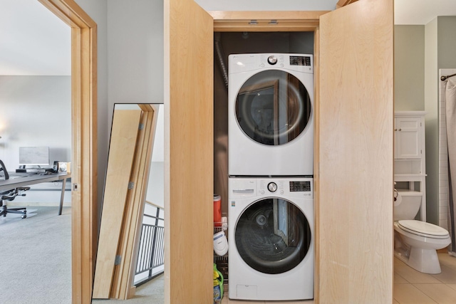 clothes washing area with estacked washer and dryer and a desk
