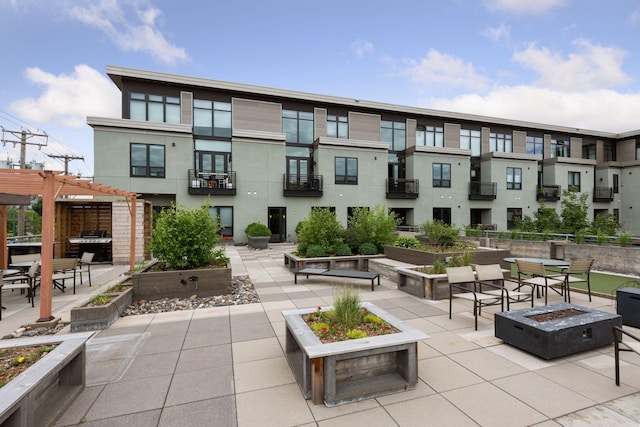 surrounding community with a fire pit, a patio area, and a pergola