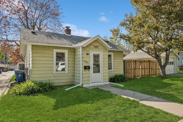 2647 Abbott Ave N, Robbinsdale, MN 55422 - bungalow-style home with a chimney, roof with shingles, and a garage