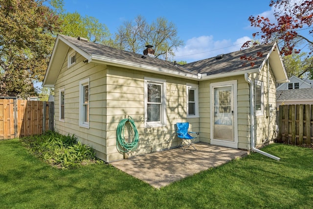2647 Abbott Ave N, Robbinsdale, MN 55422 - back of property with a chimney, a shingled roof, and a patio area