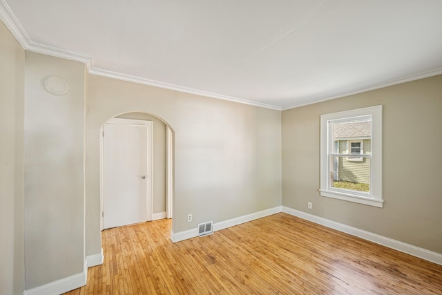 2647 Abbott Ave N, Robbinsdale, MN 55422 - unfurnished room with crown molding, light wood-style floors, arched walkways, and baseboards