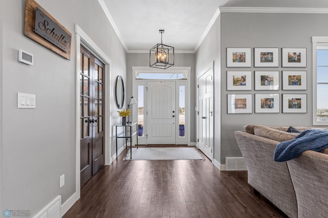 entryway with dark wood-style flooring, crown molding, baseboards, and healthy amount of natural light