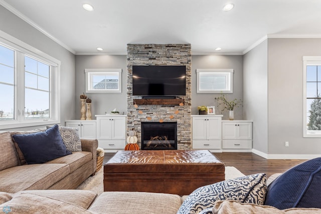 living room featuring wood finished floors, recessed lighting, a fireplace, ornamental molding, and baseboards
