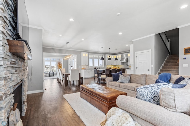 living area featuring stairs, crown molding, healthy amount of natural light, dark wood-type flooring, and recessed lighting