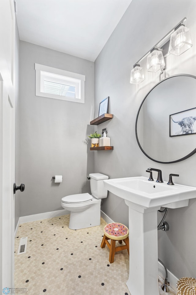 bathroom featuring toilet and baseboards