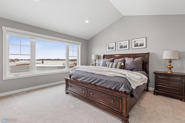 bedroom featuring vaulted ceiling, light carpet, and baseboards