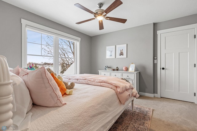 bedroom featuring light carpet, baseboards, and ceiling fan