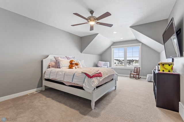 bedroom featuring light colored carpet, lofted ceiling, baseboards, and ceiling fan
