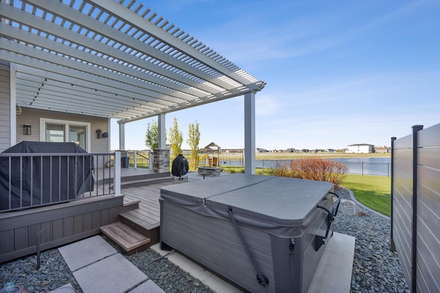 wooden deck featuring a hot tub, a water view, fence, and a pergola