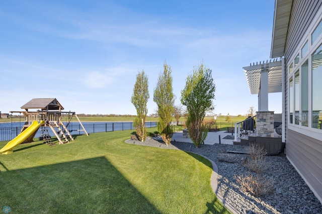 view of yard featuring a playground, a pergola, and a water view